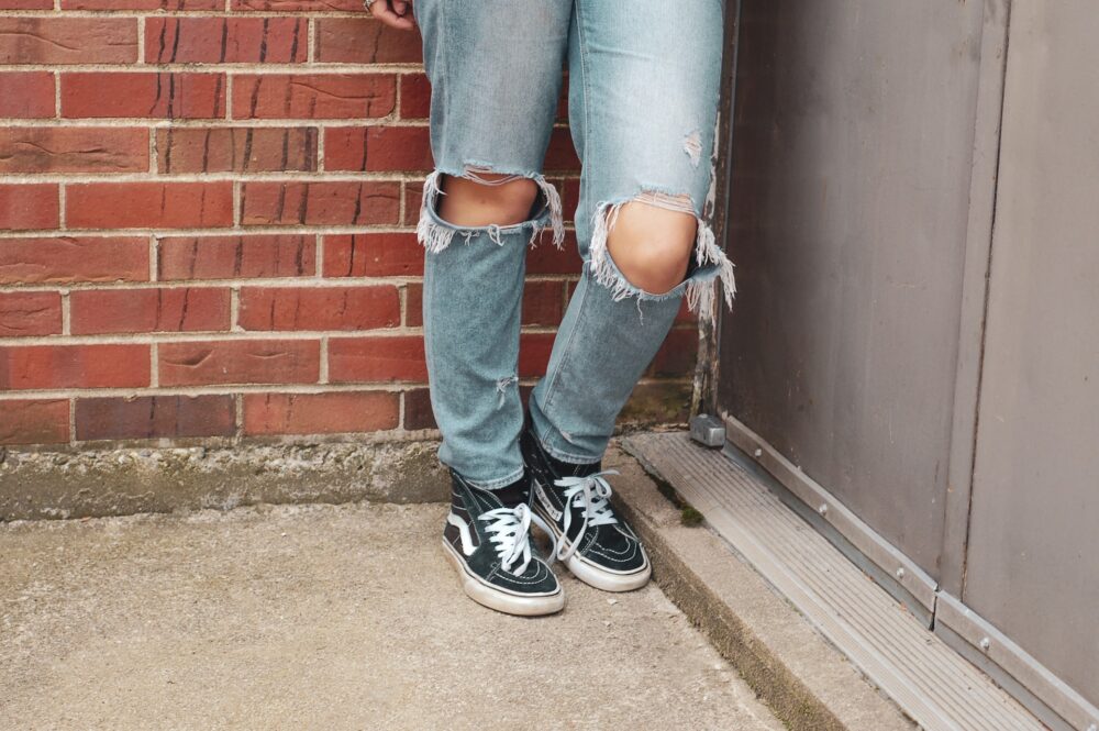 person wearing blue disressed denim jeans